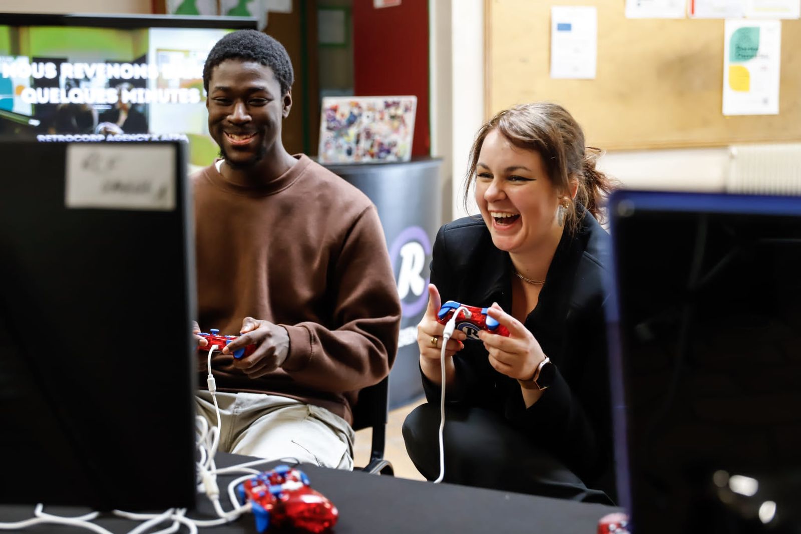 Une candidate et un candidat rient manette en main pendant un Job Quest